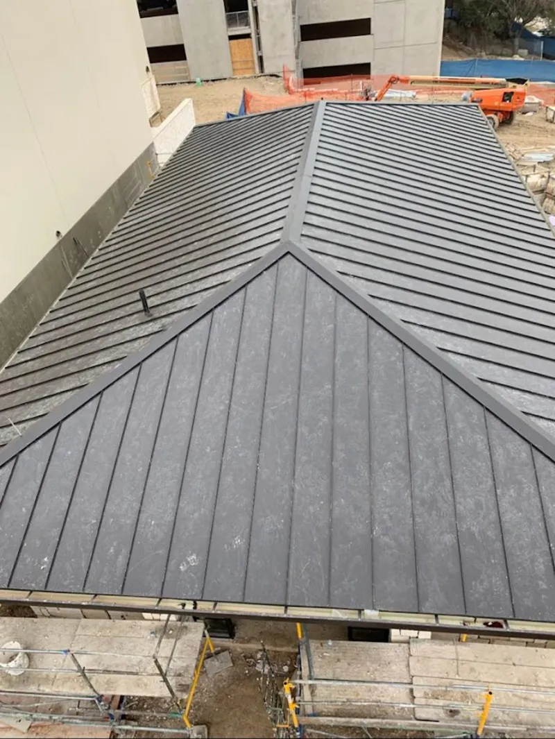 Commercial metal roof construction with crane equipment in Chandler